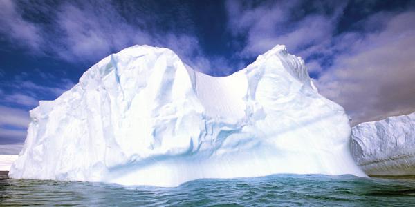 A huge iceberg with dramatic sky in the background