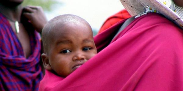 Baby peeking over mother's shoulder.
