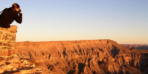Traveller leaning out over Fish River Valley, South Africa for the perfect picture.