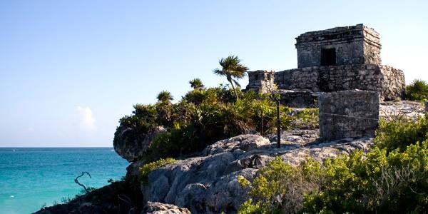 A traditional stone building sits atop the Mexican coastline