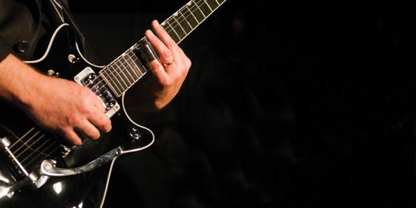 A man strumming the guitar