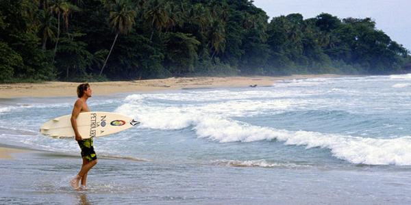 A surfer heads out into the waves