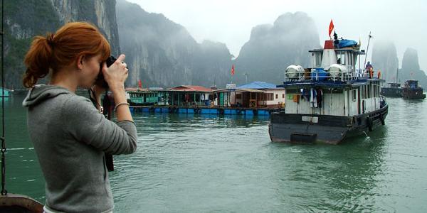 Woman photographing a boat