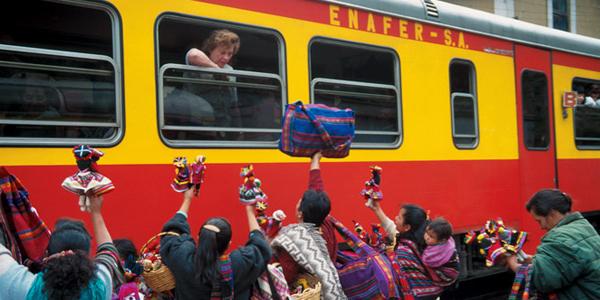 Peruvians waving to passengers on train to Machu Picchu