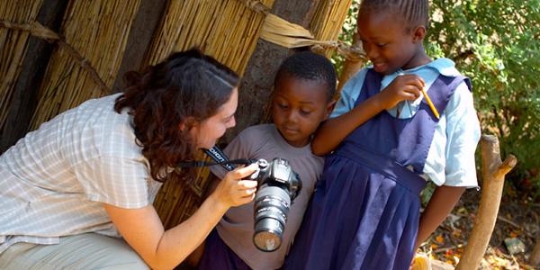 Woman showing a camera to kids in Zambia.
