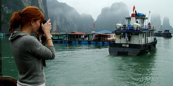 Woman photographing boat in Vietnam