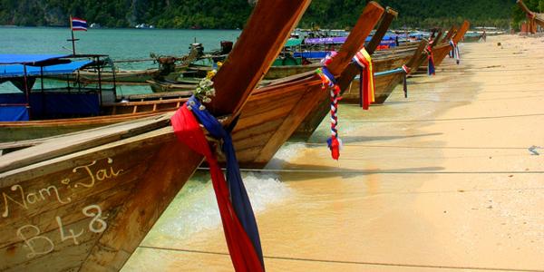 boats parked on sandy beach in Thailand