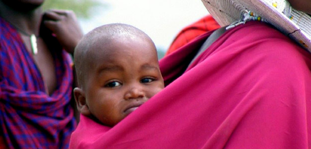 Baby peeking over mother's shoulder.