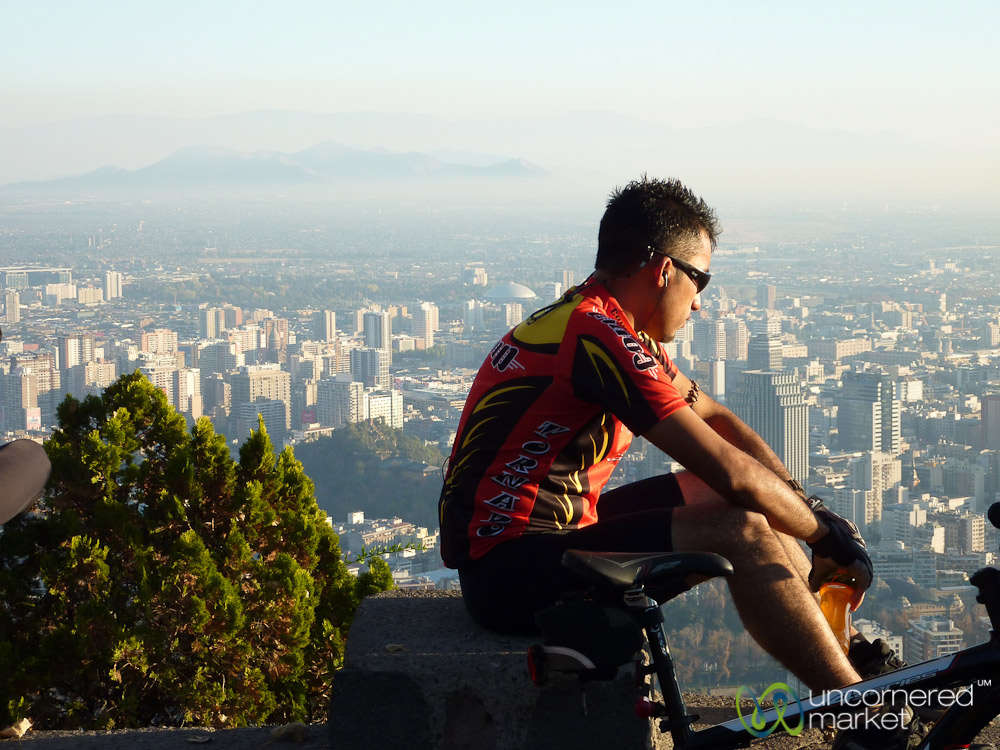 A Santiago cyclist takes a break high above the city at Cerro San Cristobal.