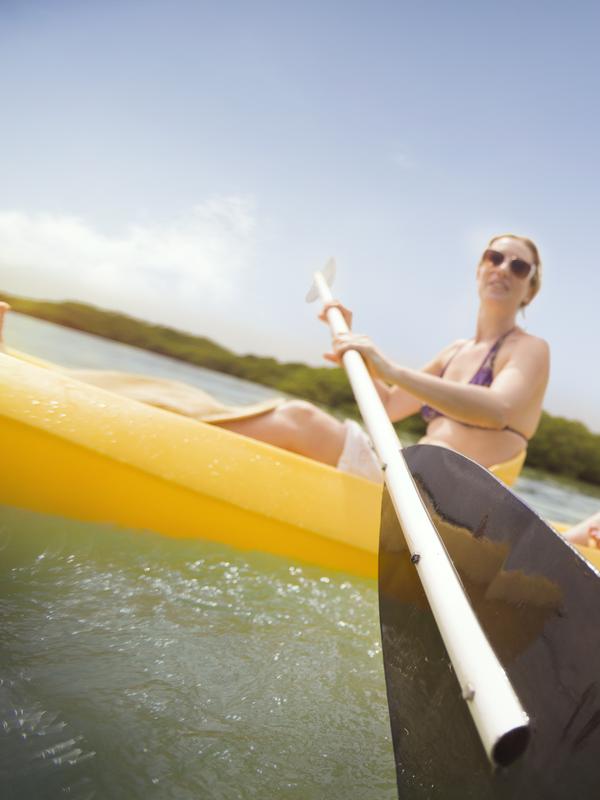 woman in a bikini padding a kayak