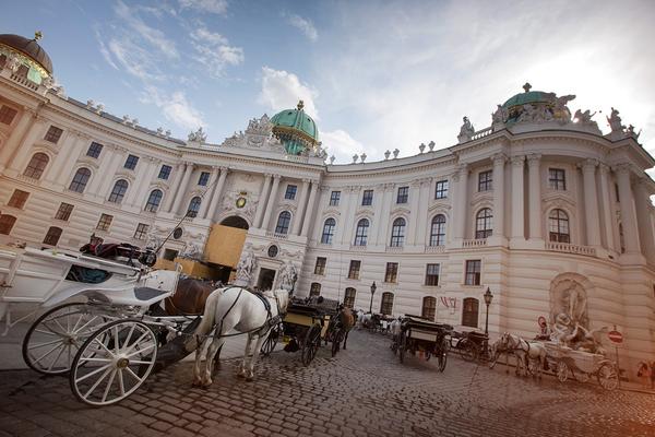 horse-pulled carriages parked outside an elegant chateau