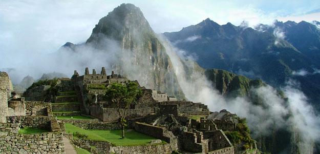 Morning fog coming through the mountain peaks in Machu Picchu