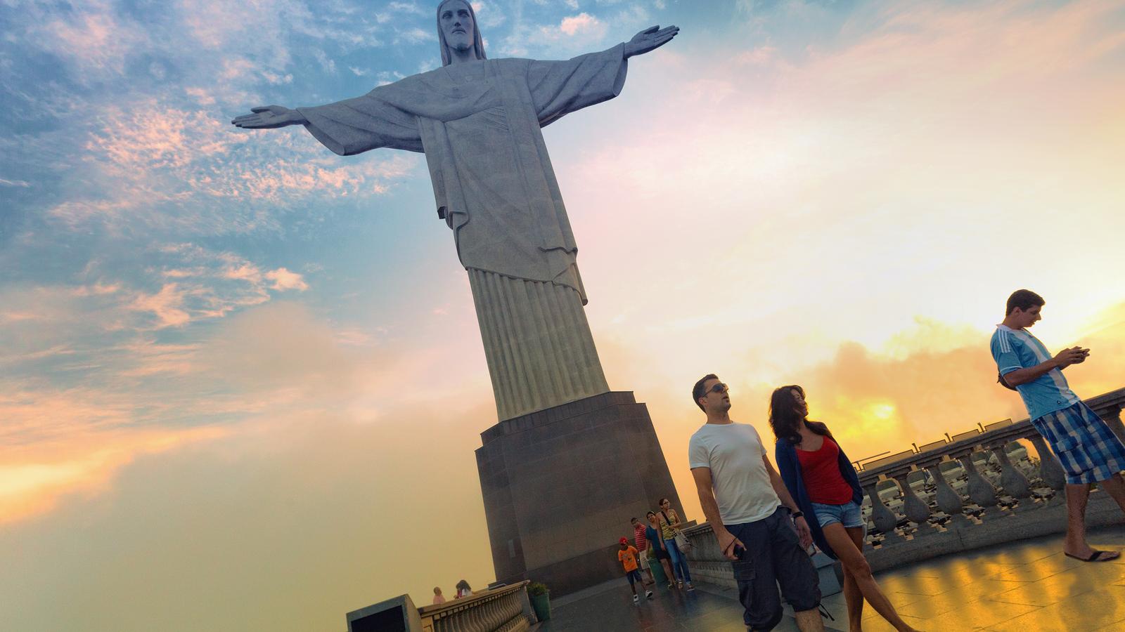 Travellers walking in the shadow of the famous Christ the Redeemer in Rio