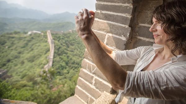 Female travller taking a photo from the Great Wall of China