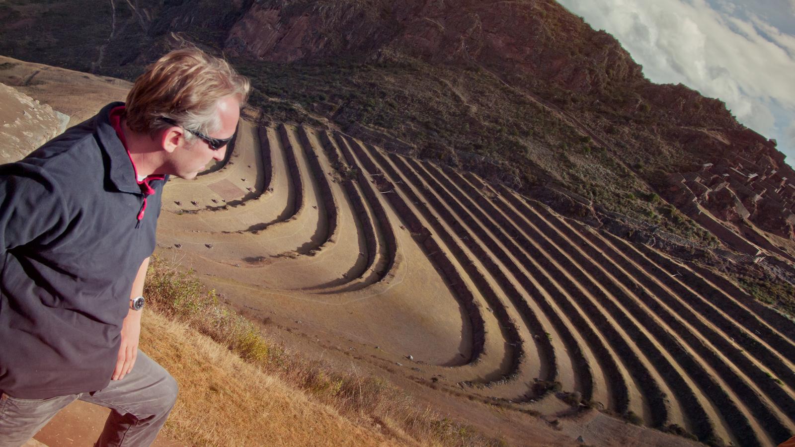 A traveller taking in the views of the Inca ruins in the Sacred Valley in Peru