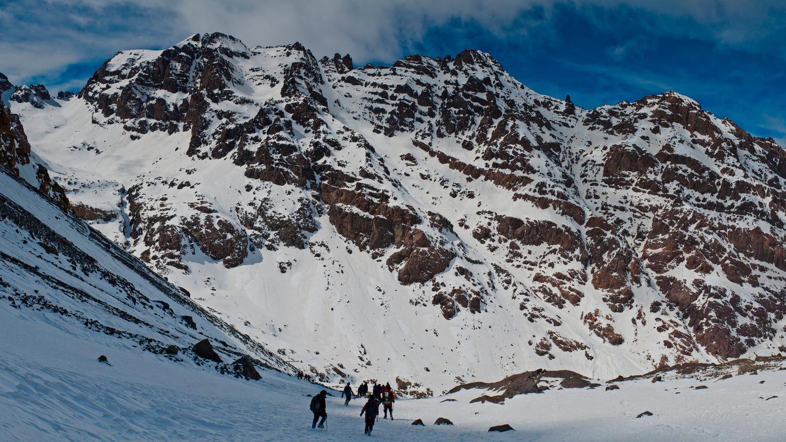 Group of travellers winter hiking through the Atlas Mountains in Morocco