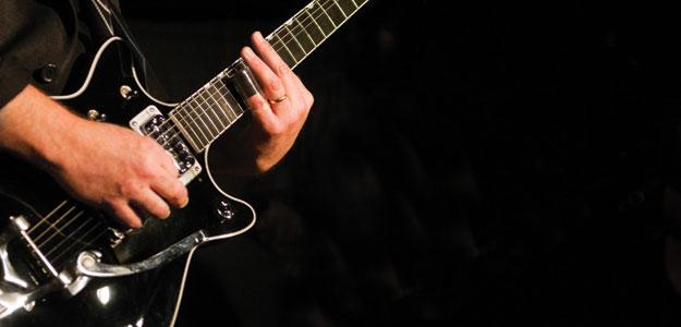 A man strumming the guitar