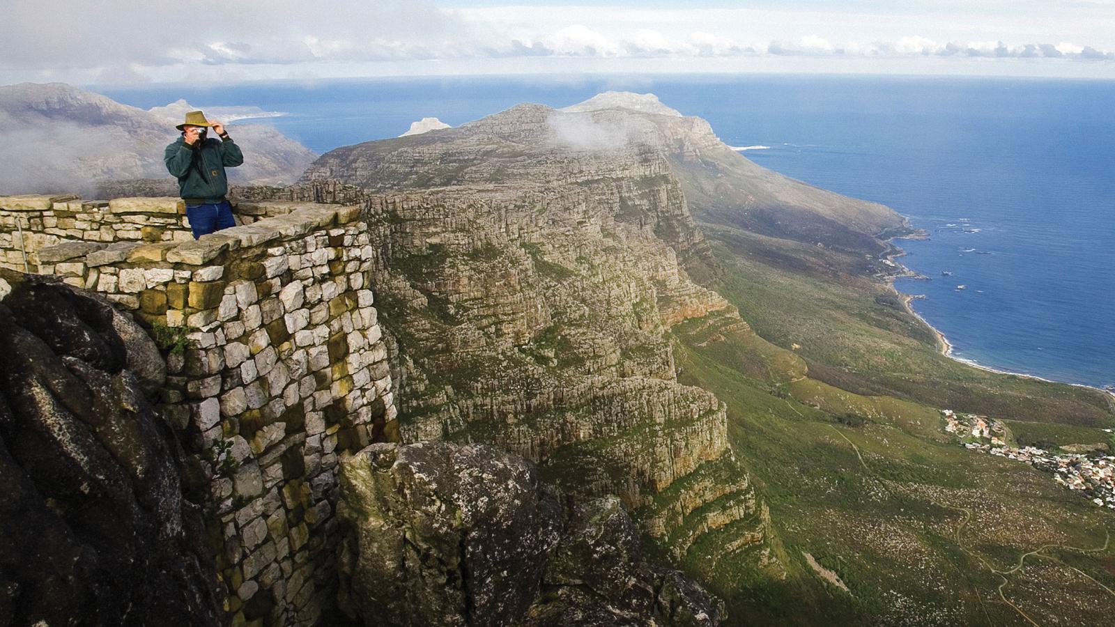 Traveller taking photos from the top of Table Mountain in South Africa