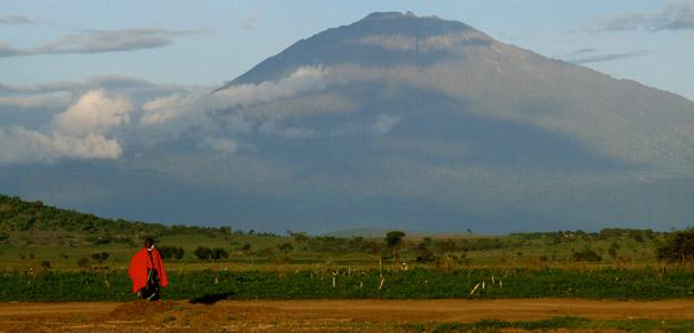 Man walking with Kilimanjaro in the background.