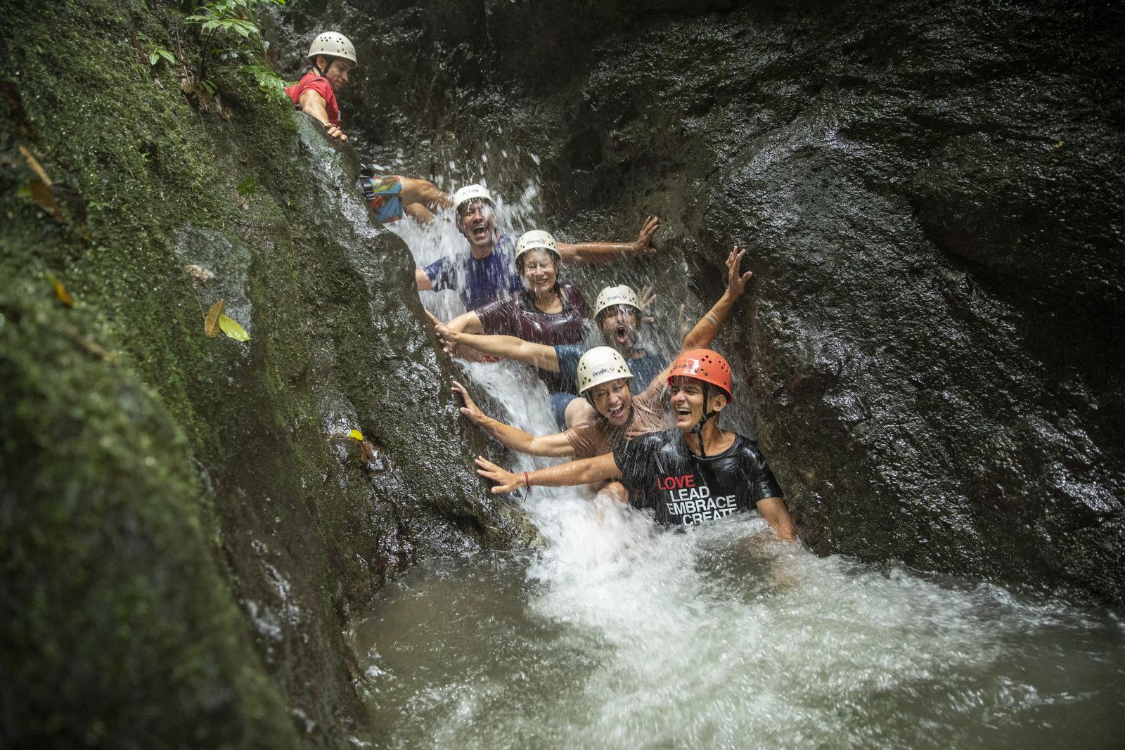 A group of travellers canyoneering down a waterfall in Costa Rica