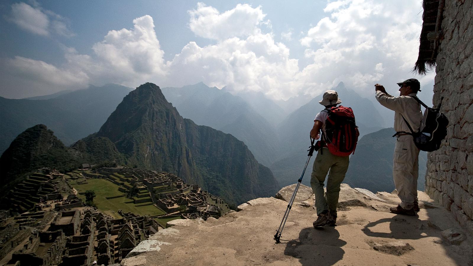 Couple taking photos of Machu Picchu in Peru