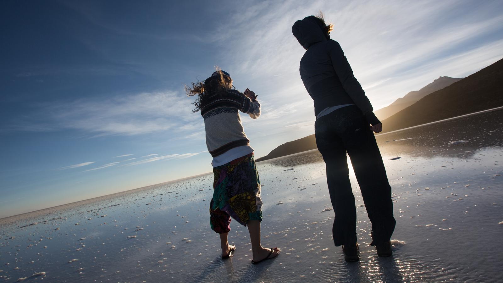 Travellers taking photos on the salt flats during sunset in Bolivia