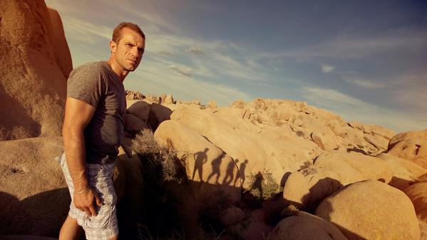 male traveller atop a rocky cliff