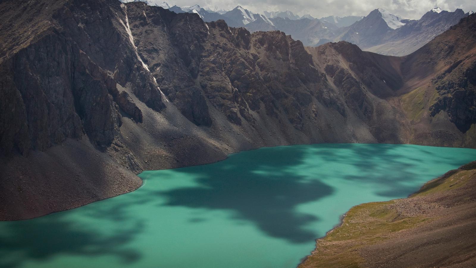 Deep turquoise lake separating the Karakol mountain range in Kyrgyzstan