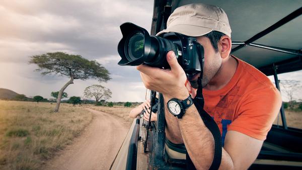 young man taking photos on a safari