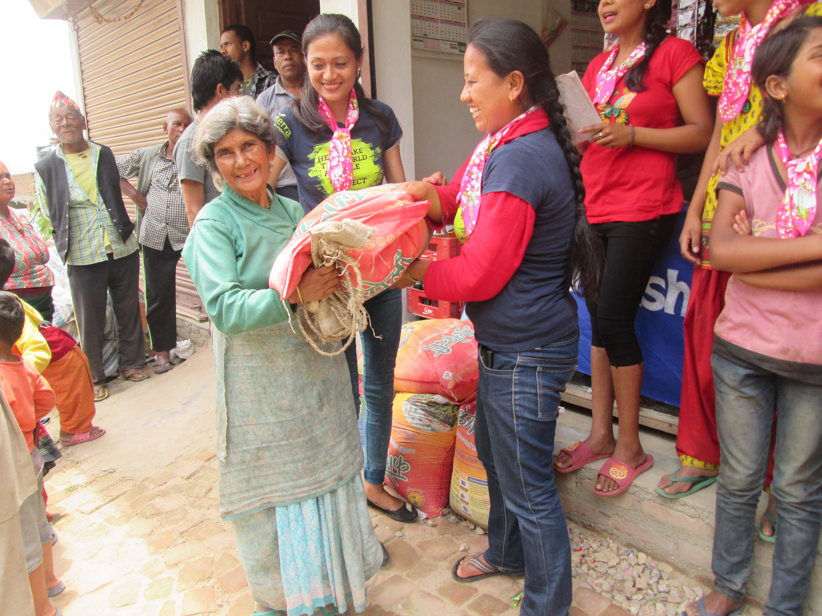 Indira and Manisha from Sisterhood of Survivors handing out bags of rice in Nuwakot just two weeks after the earthquake.