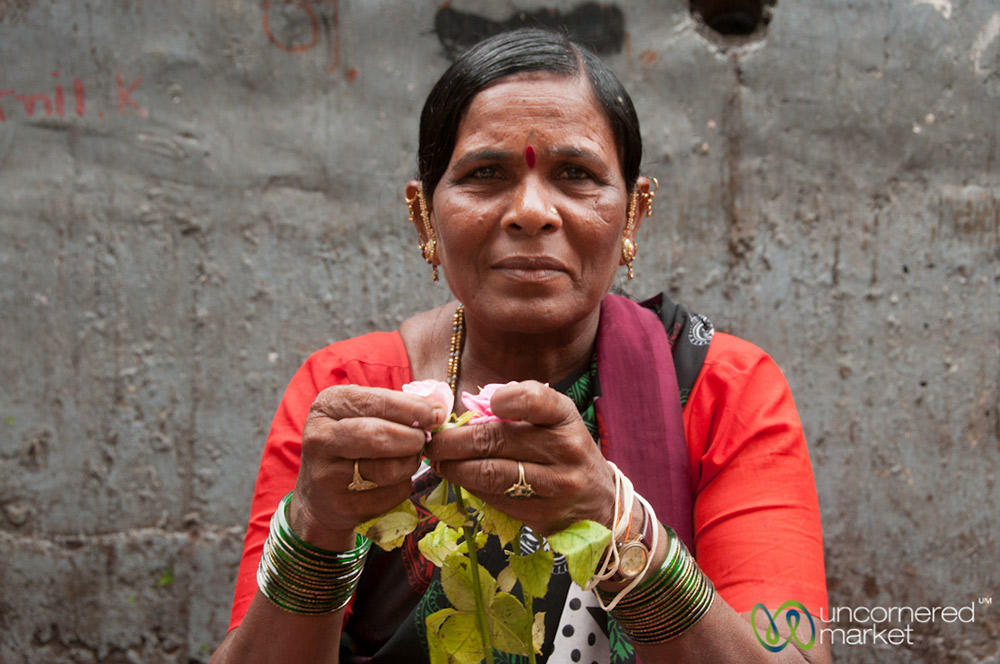 A flower vendor separates and bags rose petals.