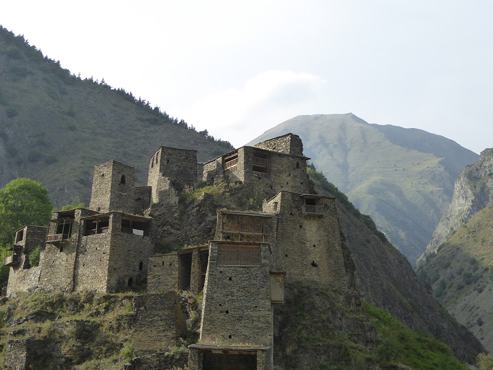 Clusters of dark stone tower houses along the Georgian trek.